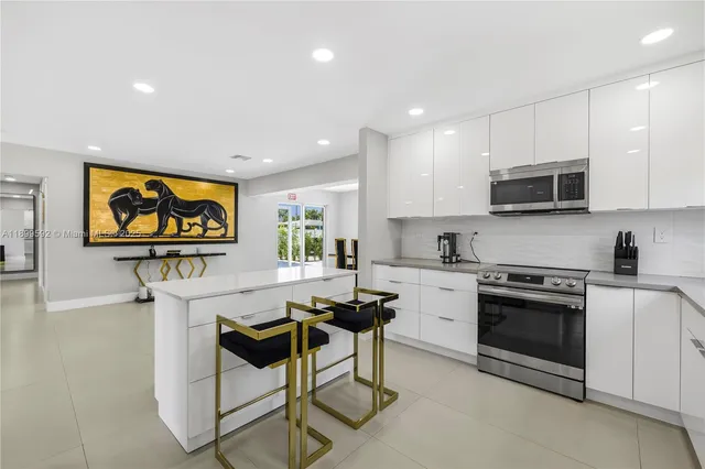 a kitchen with stainless steel appliances granite countertop a stove a sink and a microwave