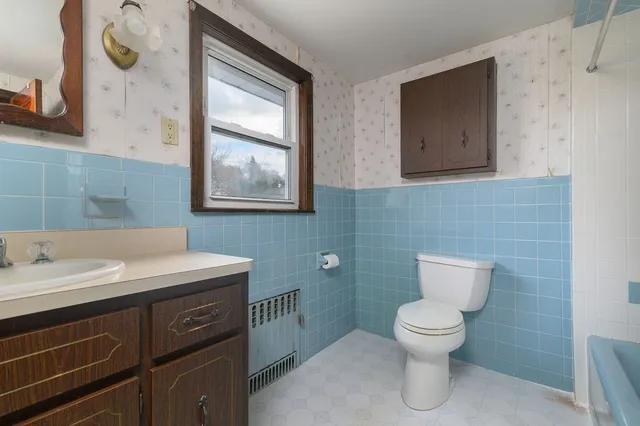 a bathroom with a toilet sink and mirror