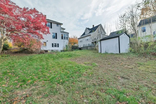 a view of a house with a big yard and large tree
