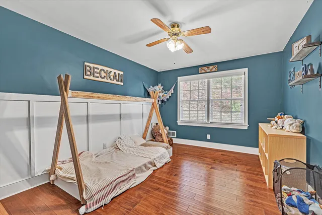 a bedroom with a bed and wooden floor
