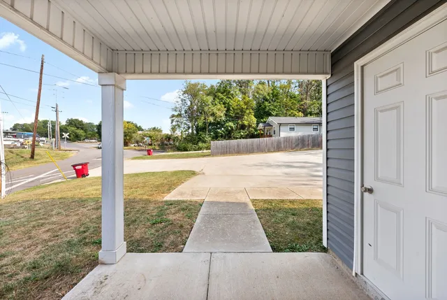 a front view of a house with a yard and car parked