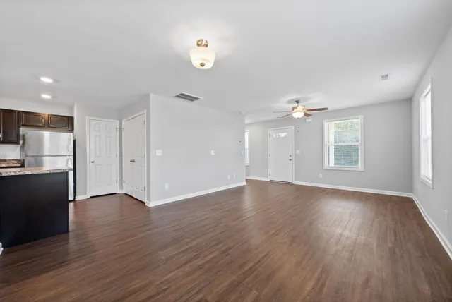 an empty room with wooden floor and windows