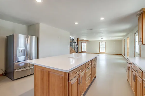 an empty room with wooden floor chandelier fan and windows