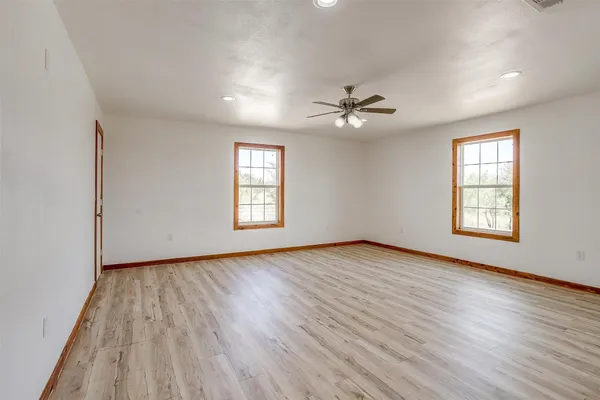 an empty room with a ceiling fan and a window