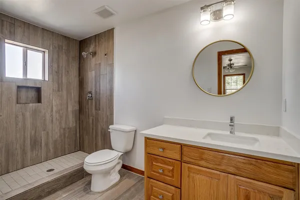 a bathroom with a sink a toilet and shower