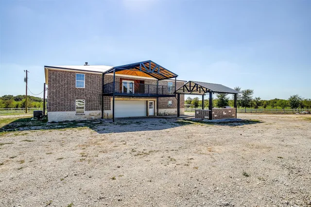 an empty room with wooden floor ceiling fan and windows