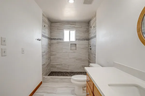 a bathroom with a sink a toilet and shower