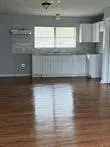 a view of a kitchen with wooden floors and a window