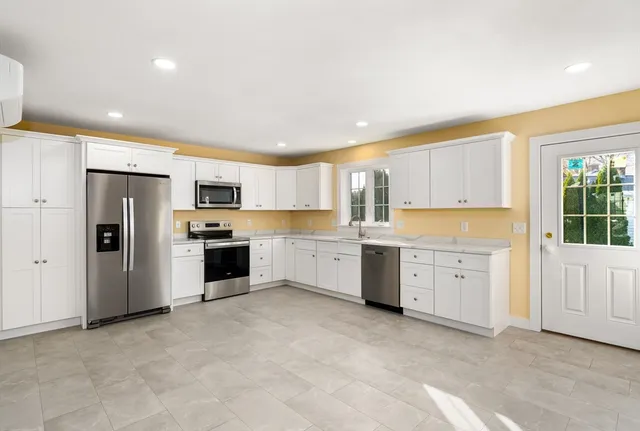 a large kitchen with white cabinets and white stainless steel appliances