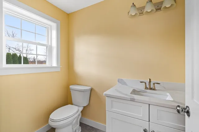 a bathroom with a sink a toilet and a window