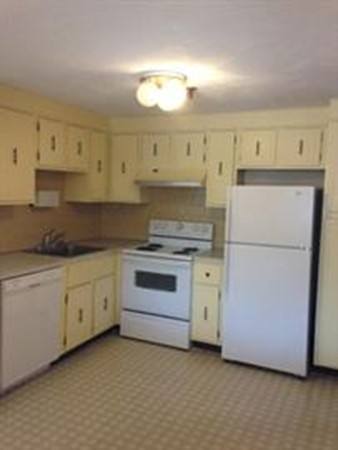 32 Spencer Road, Unit 32M Boxborough, MA 01719 - Photo 3 of 4 a kitchen with granite countertop white cabinets and white appliances