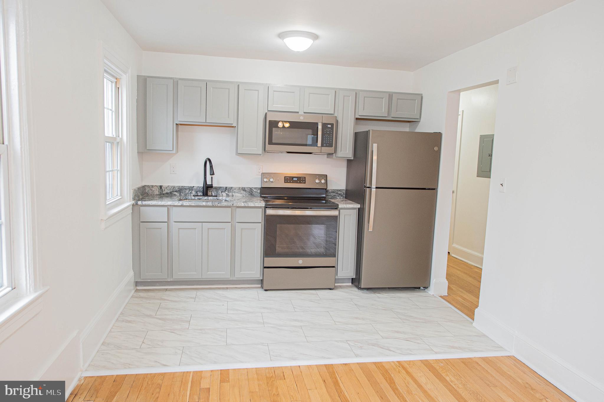 308 North Division Street, Unit 16 Salisbury, MD 21801 - Photo 20 of 61 a kitchen with a sink a refrigerator and white cabinets