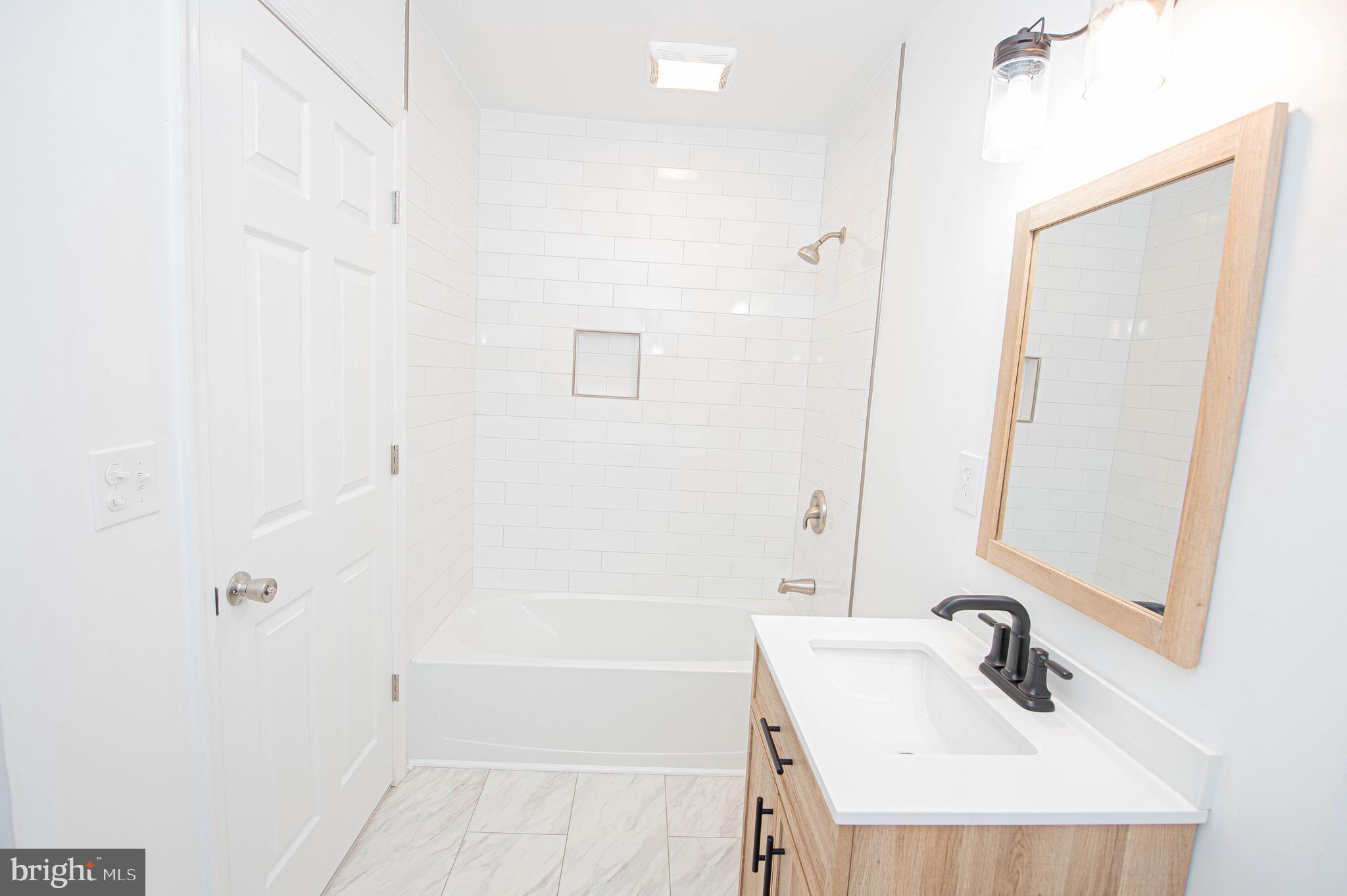 308 North Division Street, Unit 16 Salisbury, MD 21801 - Photo 50 of 61 a bathroom with a sink a shower and a mirror