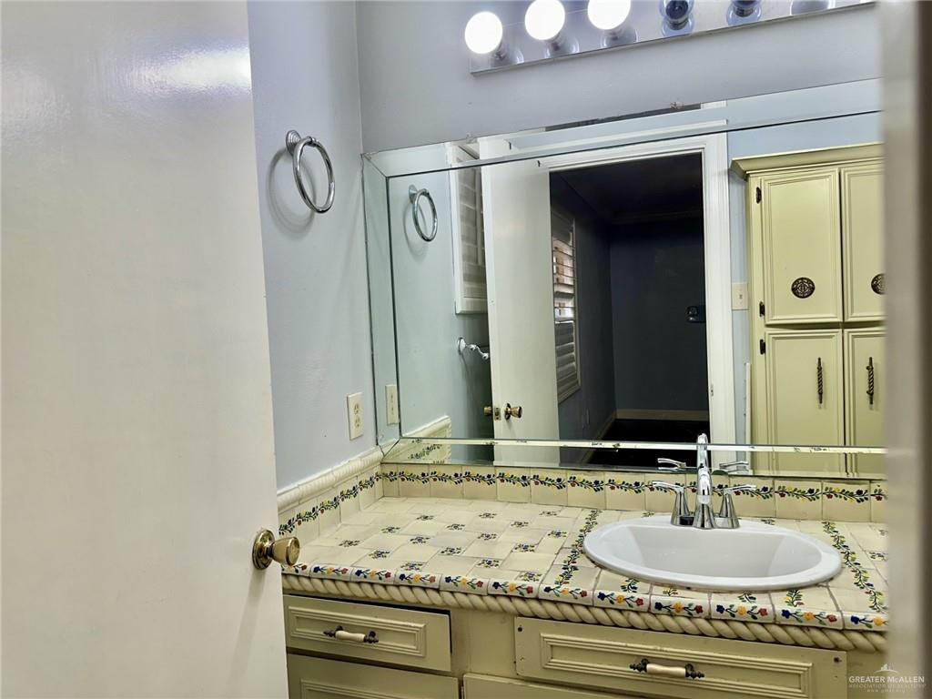 1518 Redbud Avenue McAllen, TX 78504 - Photo 20 of 39 a bathroom with a granite countertop sink and a mirror