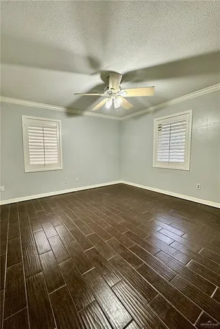 an empty room with wooden floor and fan