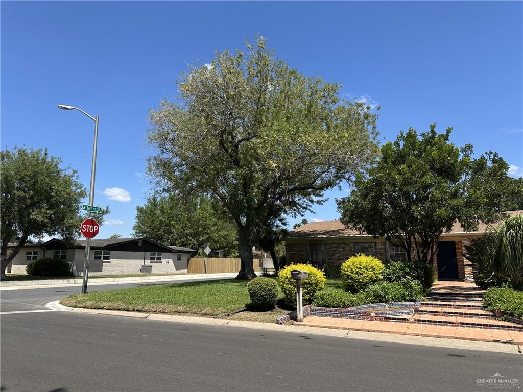 1518 Redbud Avenue McAllen, TX 78504 - Photo 4 of 39 a front view of a house with a garden and pathway