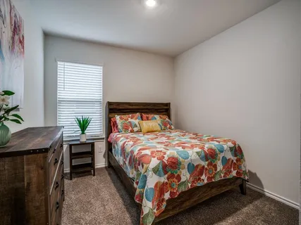a bedroom with a bed table and a window