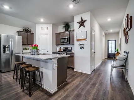 a kitchen with stainless steel appliances a refrigerator and a stove top oven