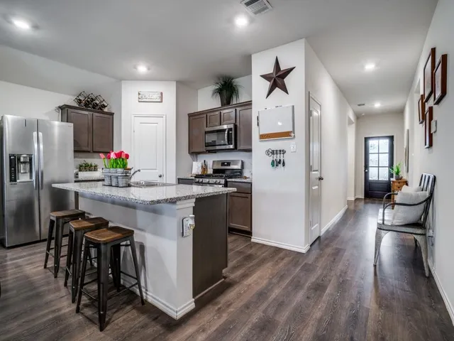 a kitchen with stainless steel appliances a refrigerator and a stove top oven