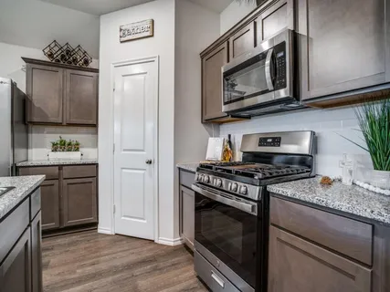 a kitchen with granite countertop cabinets stainless steel appliances and wooden floor