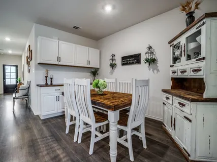 a kitchen with stainless steel appliances a stove a sink dishwasher a refrigerator with white cabinets and wooden floor