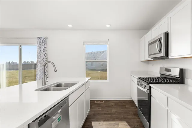 a kitchen with stainless steel appliances granite countertop a sink stove and cabinets