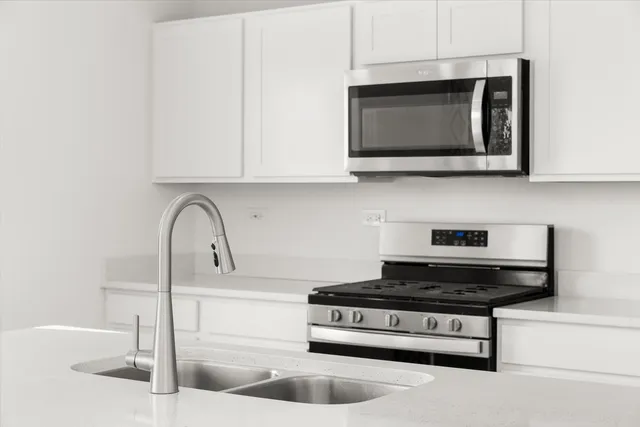 a kitchen with stainless steel appliances granite countertop a sink a microwave and cabinets