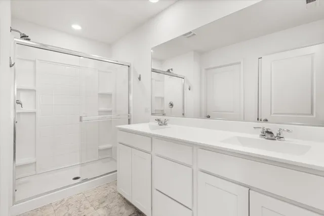 a bathroom with a double vanity sink mirror and shower