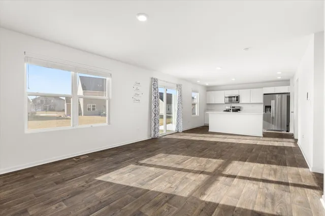 a view of empty room with wooden floor and window