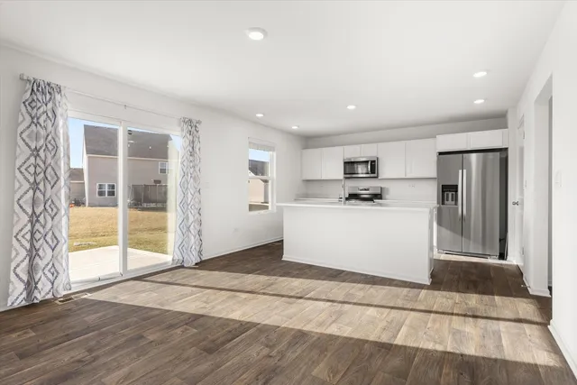a kitchen with stainless steel appliances kitchen island granite countertop a refrigerator and a sink