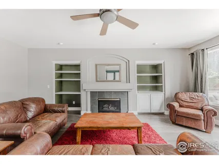 a living room with furniture fireplace and a large window
