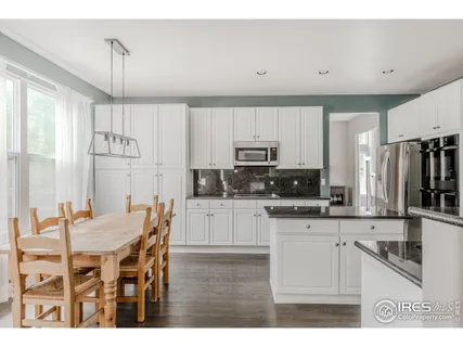a kitchen with stainless steel appliances granite countertop a sink dishwasher and a refrigerator with wooden cabinets
