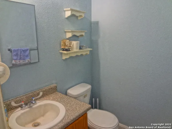 a bathroom with a granite countertop sink and a mirror