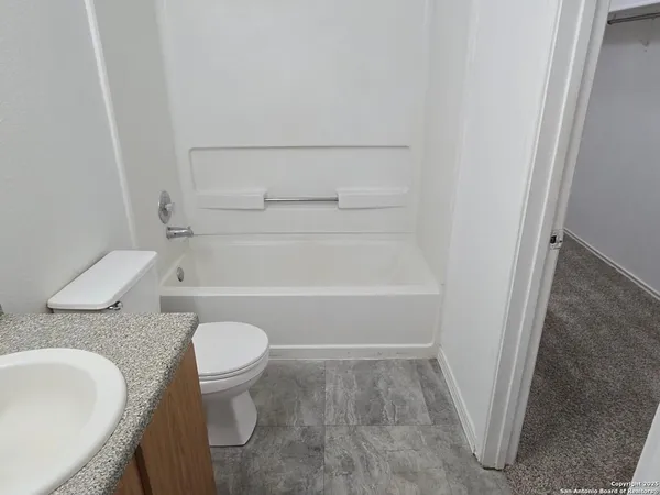 a white toilet sitting next to a bathroom sink