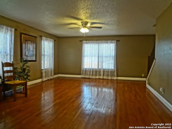 an empty room with a window and a ceiling fan