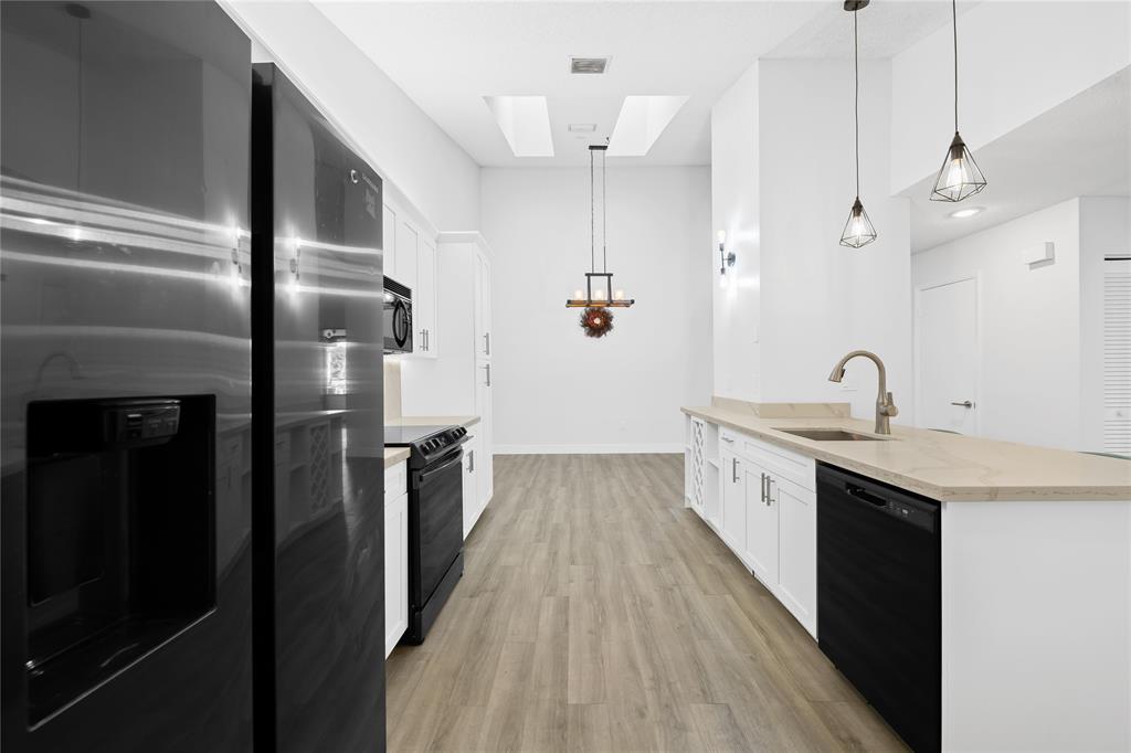 8245 Northwest 70th Street Tamarac, FL 33321 - Photo 2 of 29 a kitchen with kitchen island a sink appliances wooden floor and a window