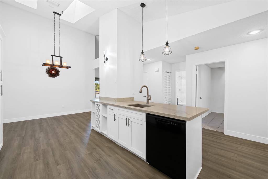 8245 Northwest 70th Street Tamarac, FL 33321 - Photo 4 of 29 a kitchen with stainless steel appliances granite countertop a sink a island a refrigerator and a wooden floor