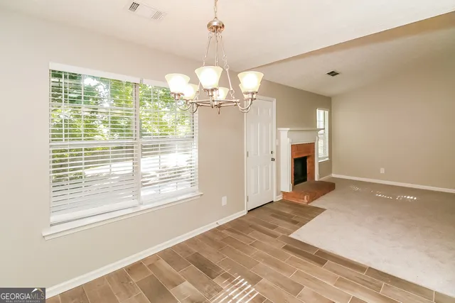 a view of a livingroom with a chandelier fan and kitchen view