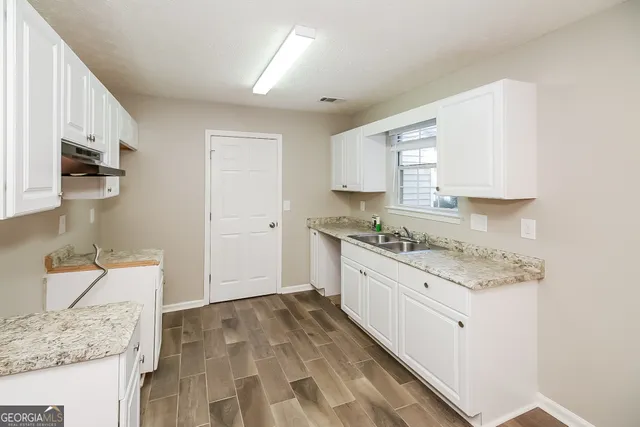 a kitchen with granite countertop white cabinets and white appliances