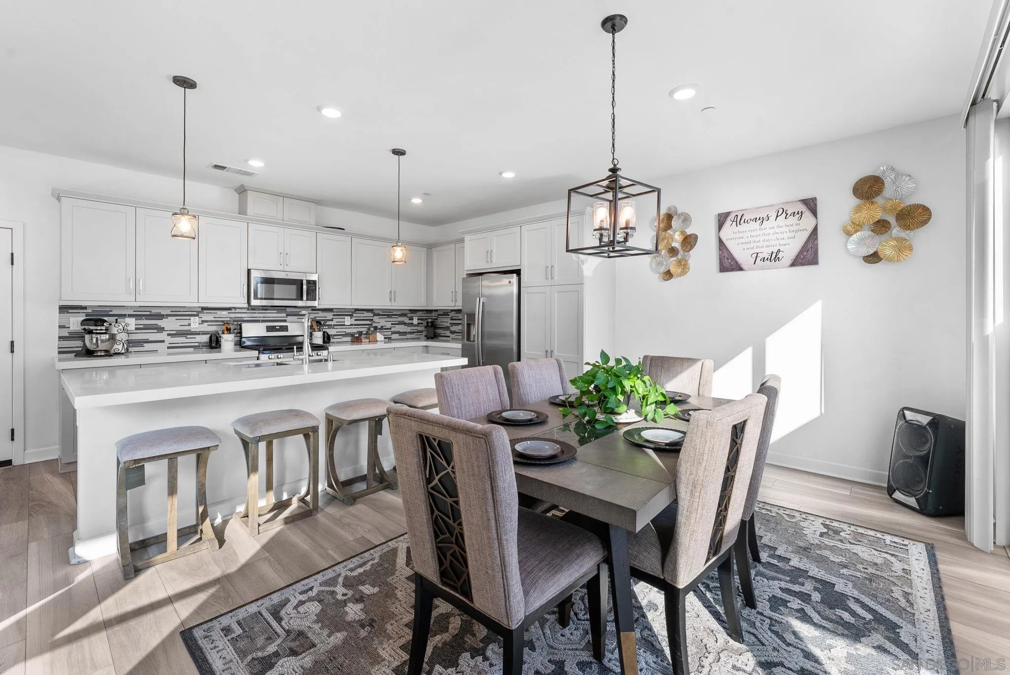 10129 Hercules Way Spring Valley, CA 91977 - Photo 11 of 52 a kitchen with stainless steel appliances kitchen island granite countertop a dining table chairs stove refrigerator and cabinets