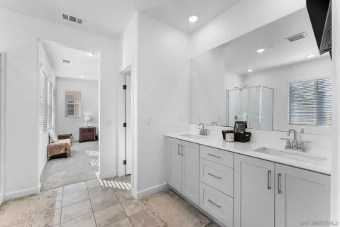 a spacious bathroom with a double vanity sink and mirror