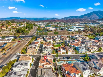 an aerial view of residential houses with outdoor space and city view