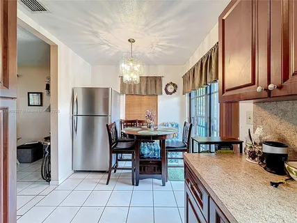 a kitchen with refrigerator and chairs