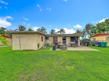 a view of a house with backyard and sitting area