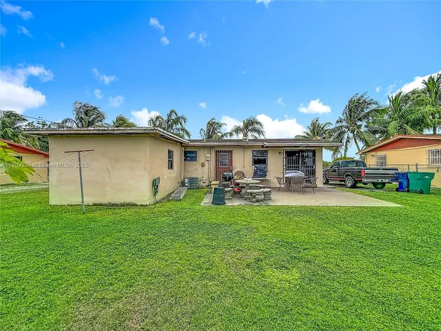 a view of a house with backyard and sitting area