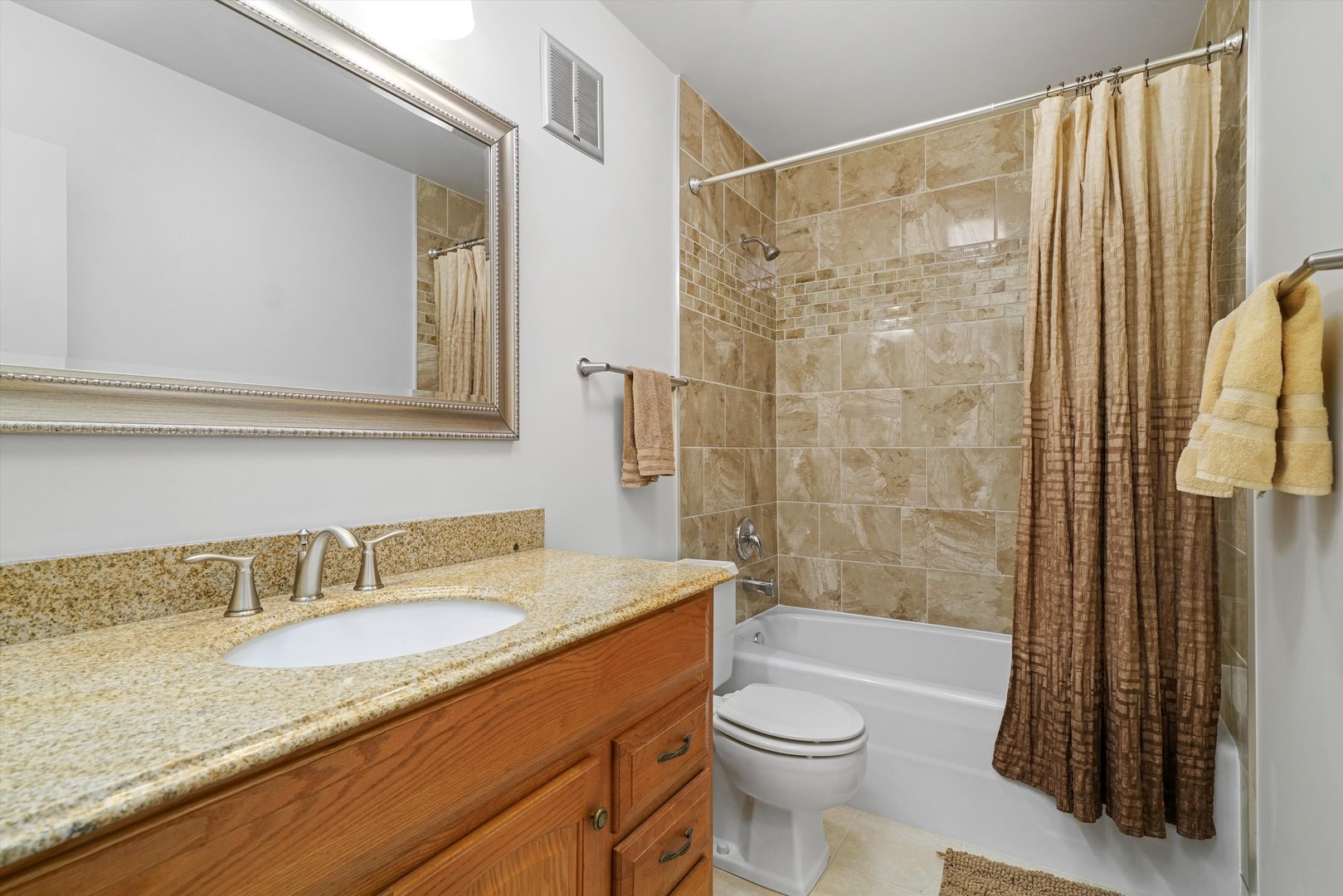 1405 East Central Road, Unit 110B Arlington Heights, IL 60005 - Photo 26 of 33 a bathroom with a granite countertop sink toilet and shower