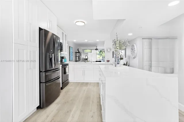 a kitchen with stainless steel appliances kitchen island a refrigerator and a sink
