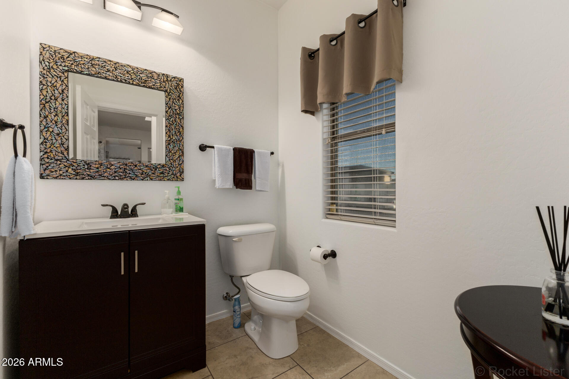 4676 East Redfield Road Gilbert, AZ 85234 - Photo 11 of 32 a bathroom with a toilet a sink and mirror