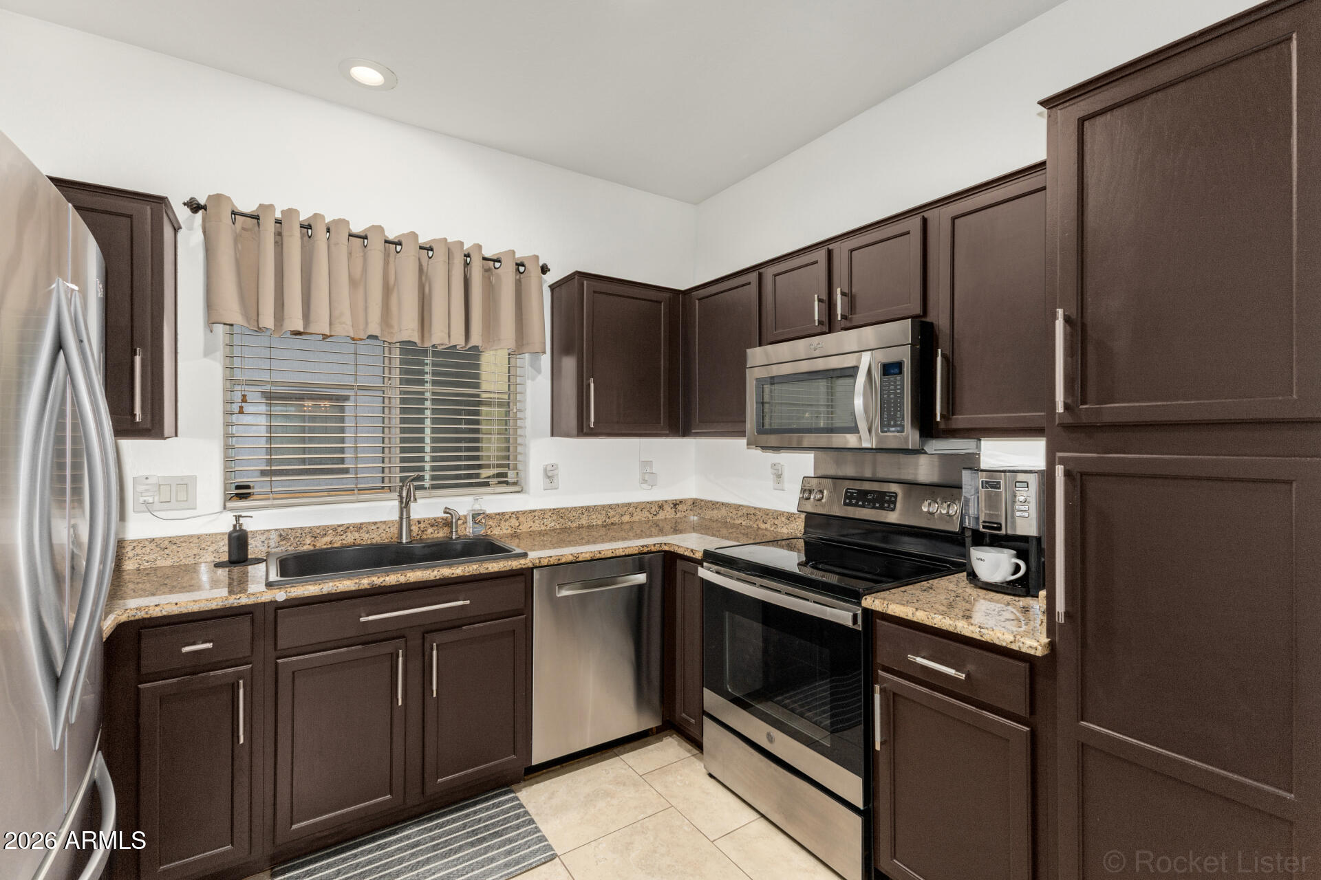 4676 East Redfield Road Gilbert, AZ 85234 - Photo 9 of 32 a kitchen with stainless steel appliances granite countertop a sink stove and refrigerator