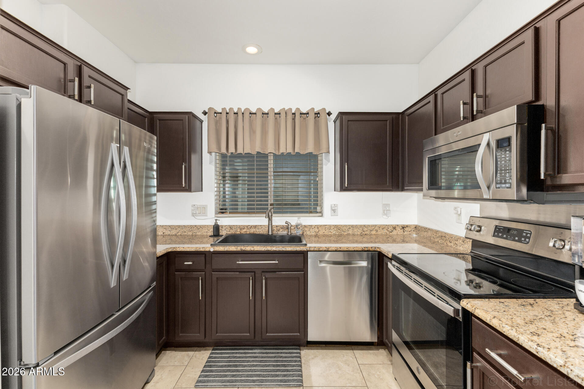 4676 East Redfield Road Gilbert, AZ 85234 - Photo 10 of 32 a kitchen with stainless steel appliances granite countertop a sink stove microwave and refrigerator